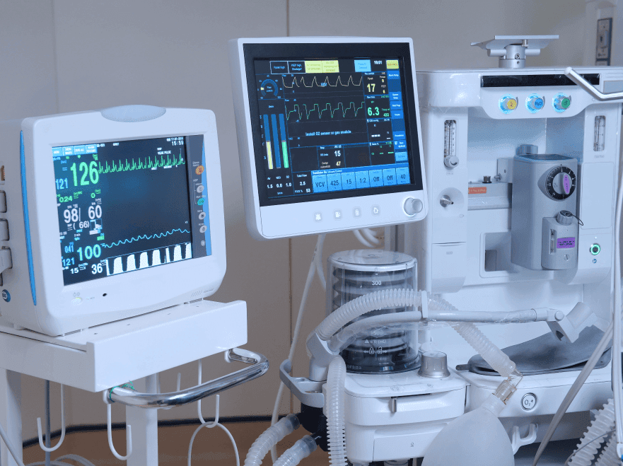 Medical machinery screens that track vitals with various numbers, charts and lines displayed on screen