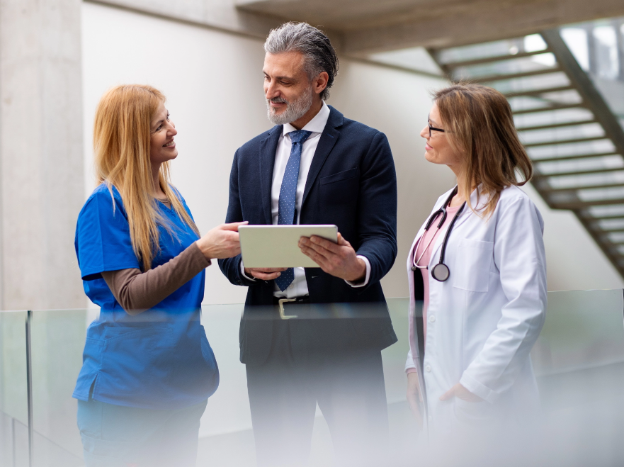 Three professionals talking over a tablet